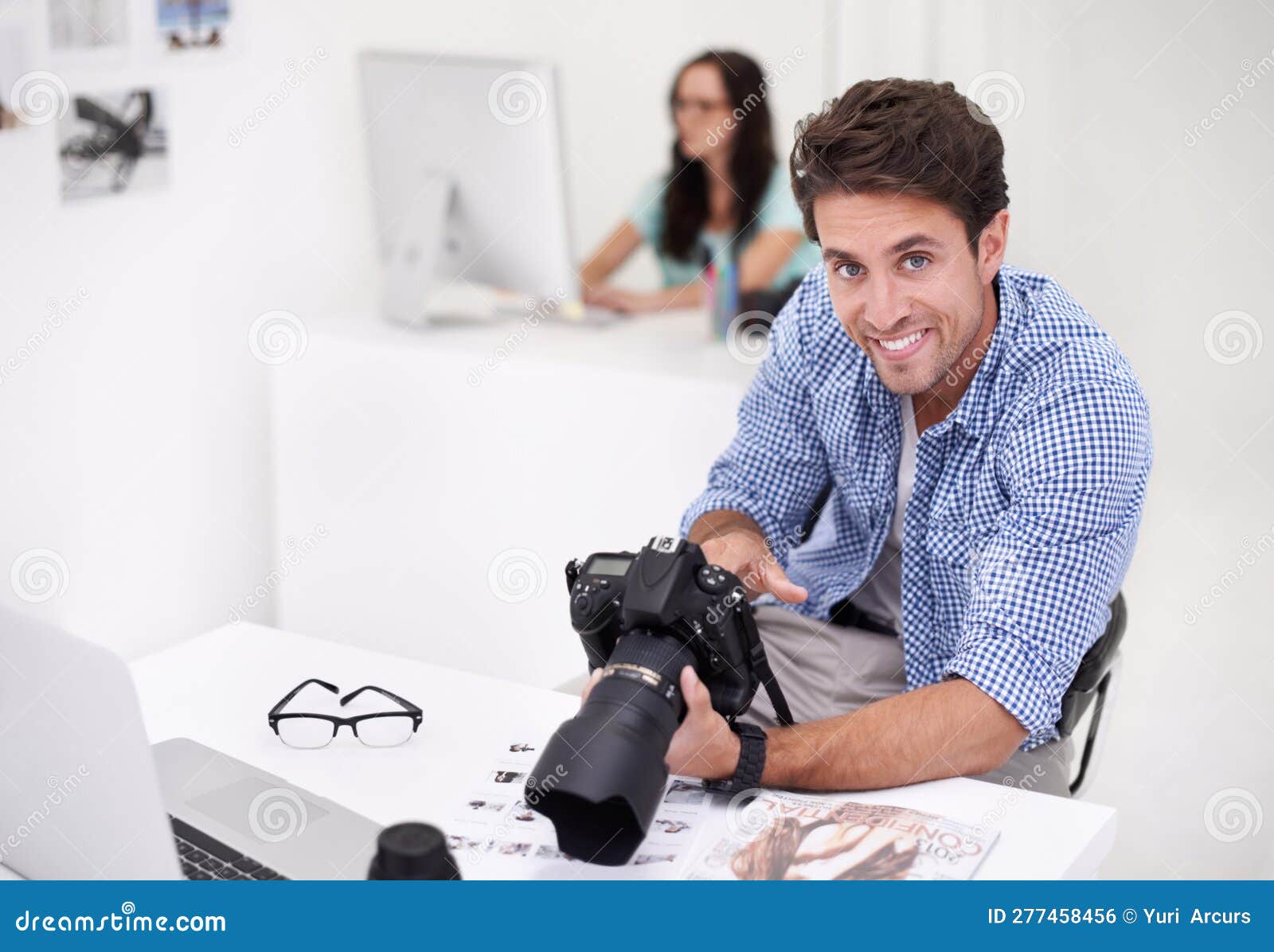 Using the Tools of the Trade Two Photographers Sitting in Their Office 
