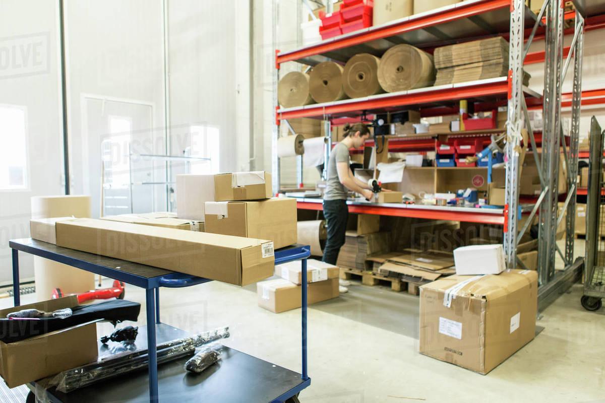 Manual worker packing box in distribution warehouse Stock Photo 