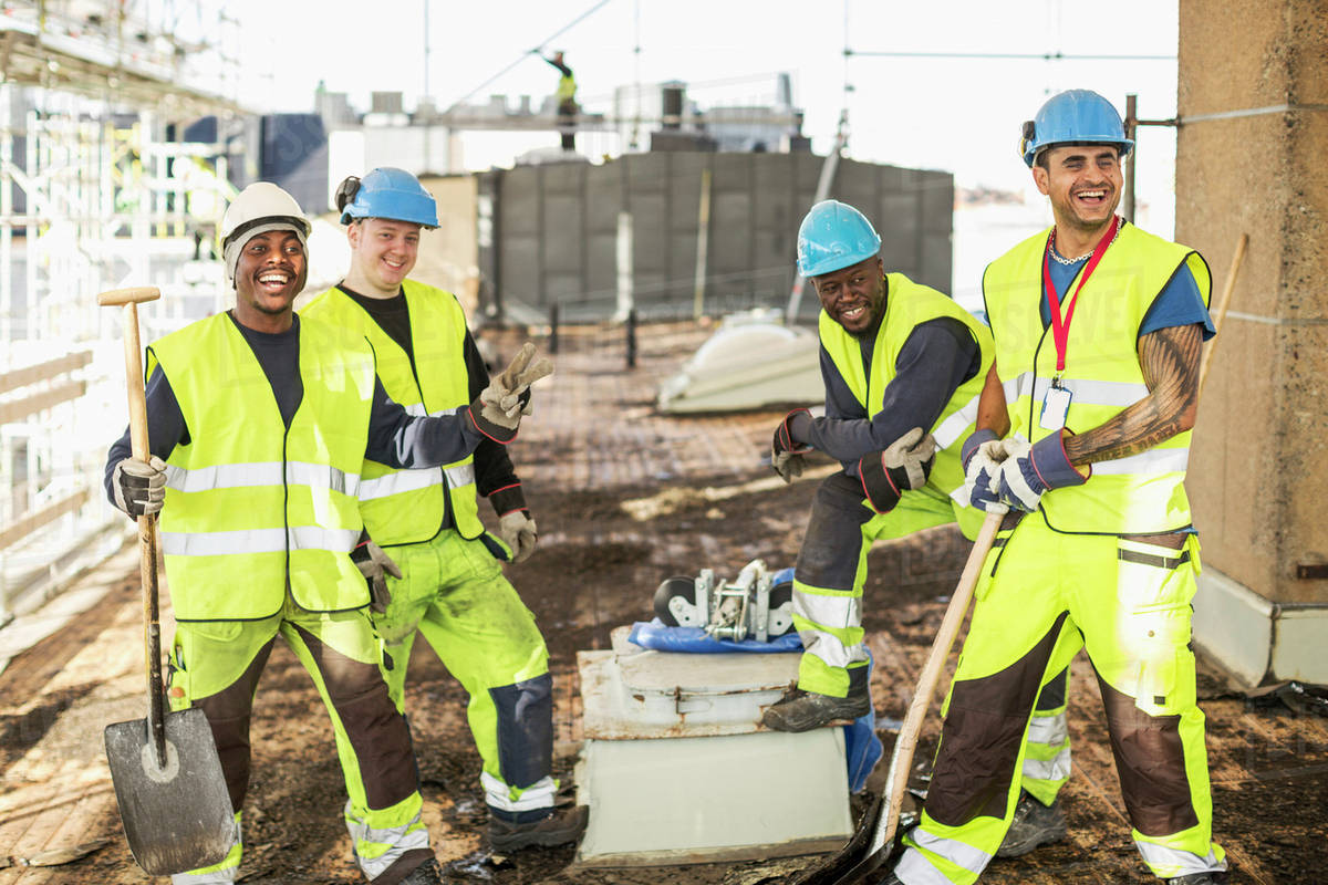 Happy construction workers at construction site Stock Photo Dissolve