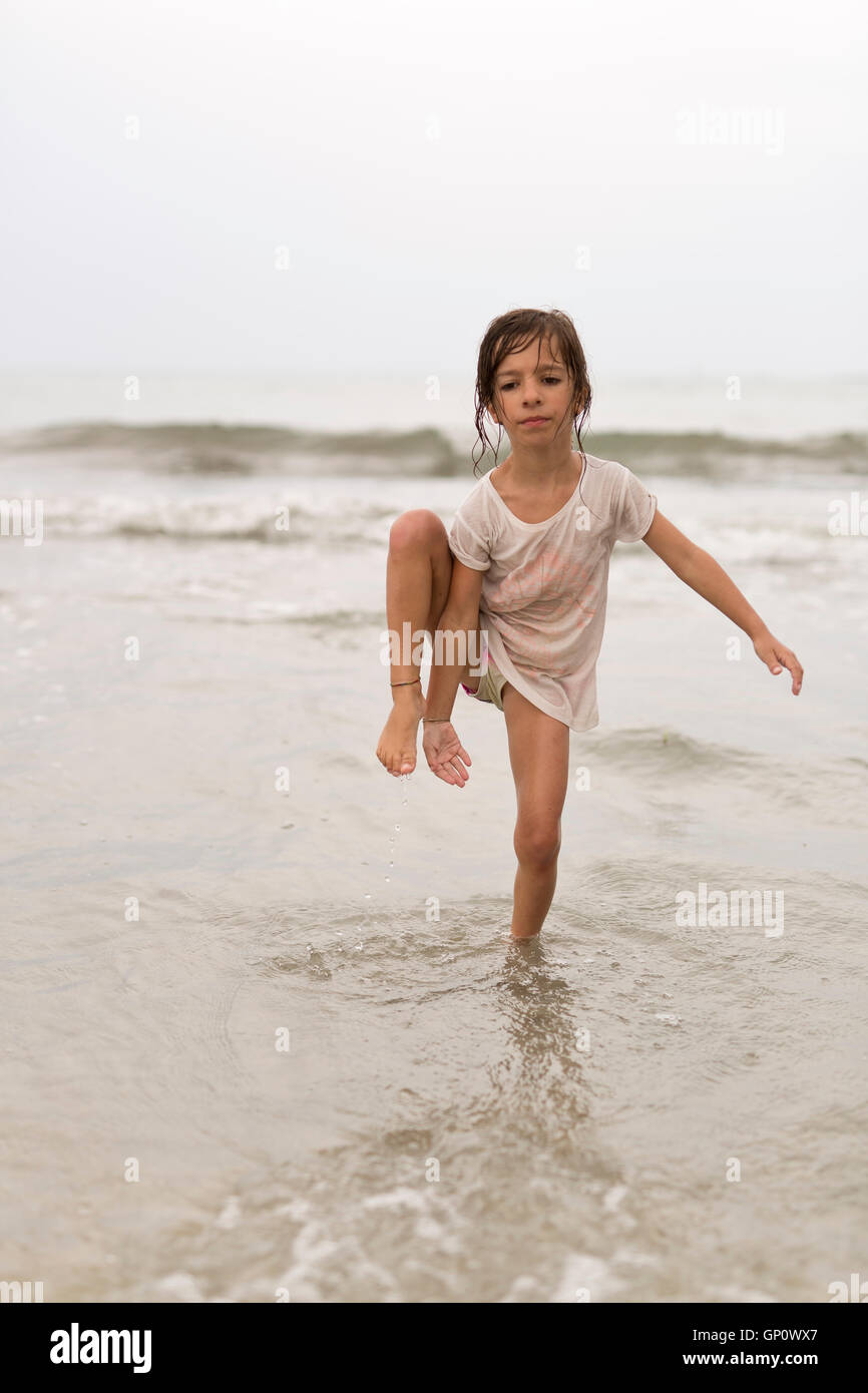 Little girl on a beach doing water gymnastics Stock Photo Alamy