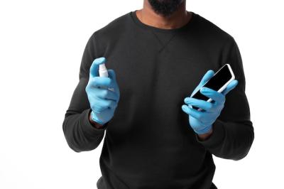 Young Man Disinfecting Gadgets Surfaces During Coronavirus Pandemic | Free Stock Photo