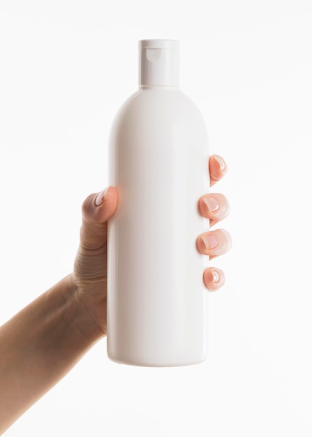 Hand holding cosmetic bottle – Free Stock Photo Download