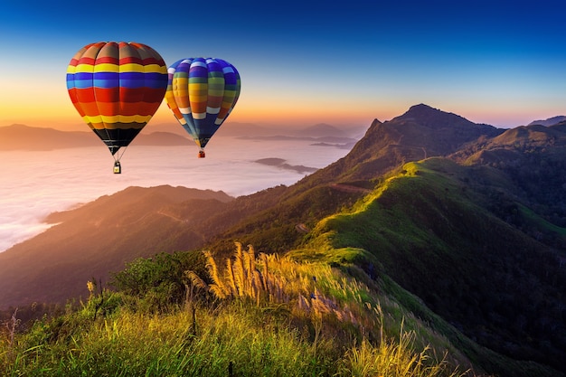 Landscape of Morning Fog and Mountains with Hot Air Balloons at Sunrise