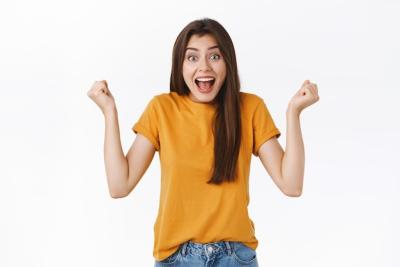 Cheerful lucky relieved attractive woman winning prize fist pump joyfully triumphing yelling from happiness rejoicing rooting for team watching exciting game standing white background