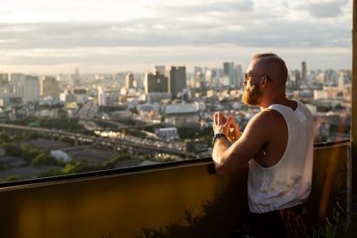 Caucasian handsome bearded man enjoying sunset and view of Bangkok city from high floor – Free Stock Photo Download