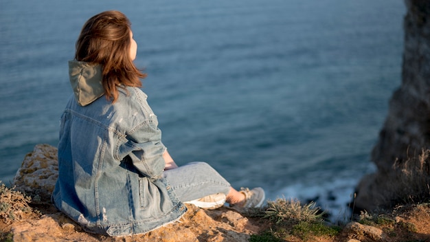 From behind shot woman and ocean