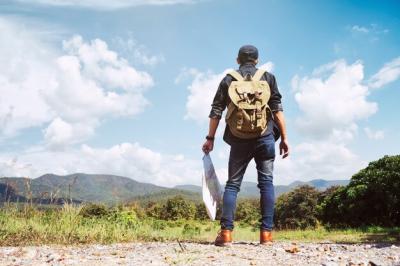 Young Man Traveler with backpack relaxing outdoor