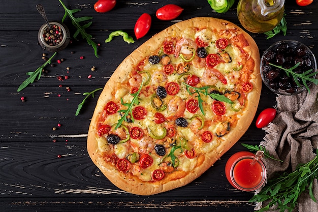 Delicious Seafood Shrimps and Mussels Pizza on a Black Wooden Table