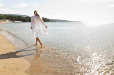 Back view of woman enjoying the beach sands