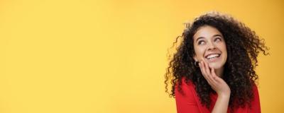 Young Woman with Curly Hair Laughing Silly and Carefree in Red Blouse