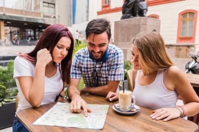 Group of friends looking at map in restaurant – Free Download