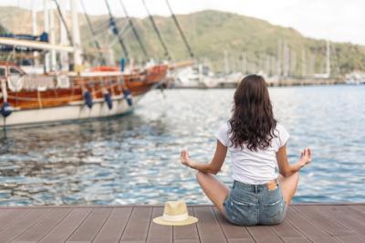 Young Woman Sitting on the Shore of a Port