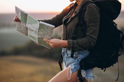 Woman hiking in the mountains and looking in the map