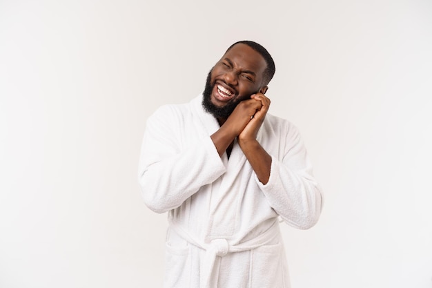 African American man wearing a bathrobe showing surprise and happiness isolated on white background