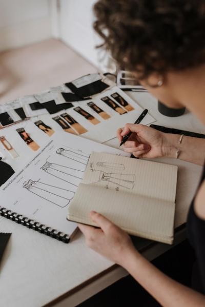 Businesswoman and Fashion Designer Reviewing Clothes Design Sketches