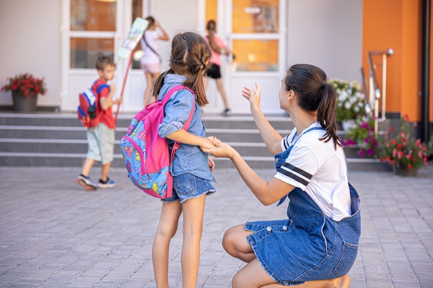 Happy Little Girl Going Back to School with Caring Mom