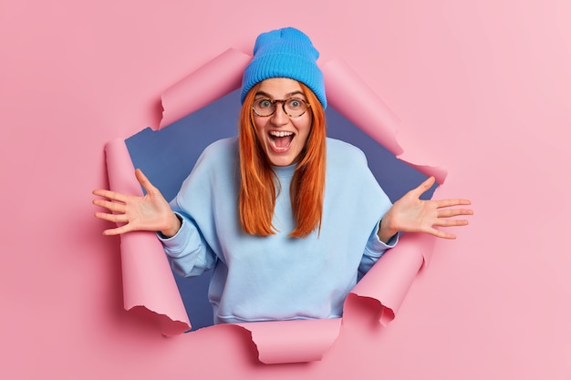 Positive Ginger Young Woman Exclaiming and Spreading Palms in Excitement