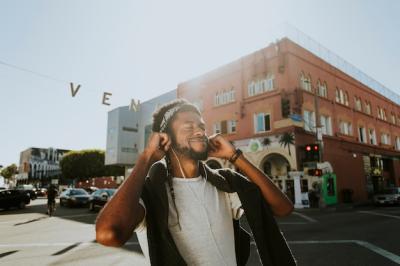 Young man listening to music while strolling through the city