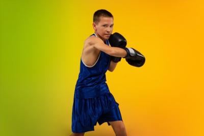 Teenage Boxer in Motion Against Gradient Neon Studio Background