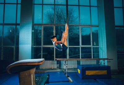 Little male gymnast training in gym, flexible and active