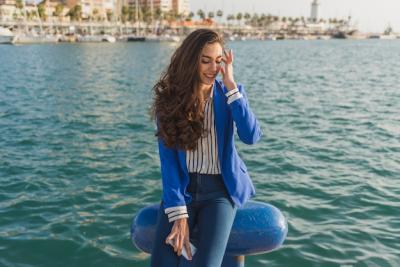 Pensive Young Woman with Port Background