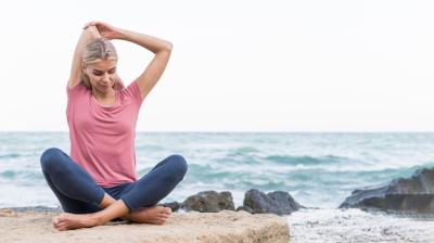 Pretty blonde woman stretching at the beach – Free Stock Photo