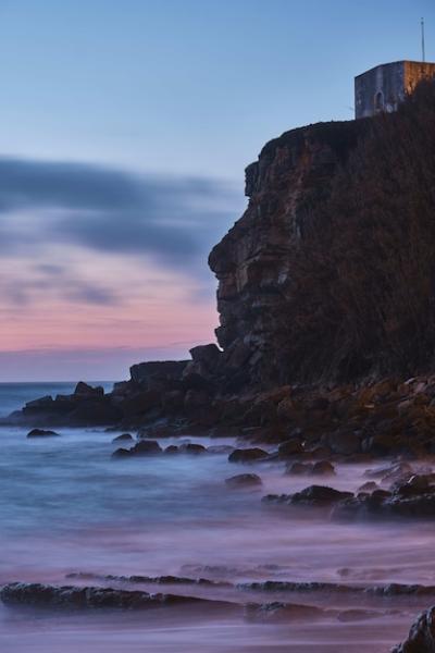 Vertical shot of a building at the top of the cliff