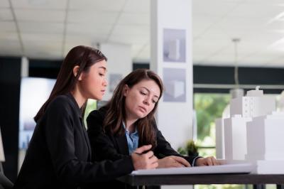 Architects Working with Blueprints in Coworking Space