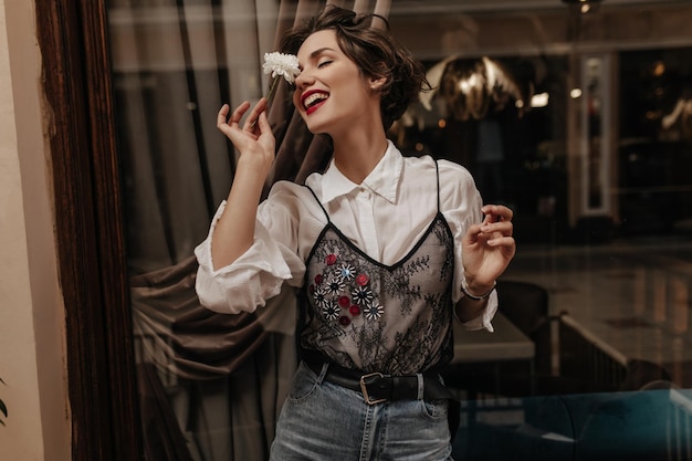 Happy Woman with Bright Lips in White Shirt Holding Flower