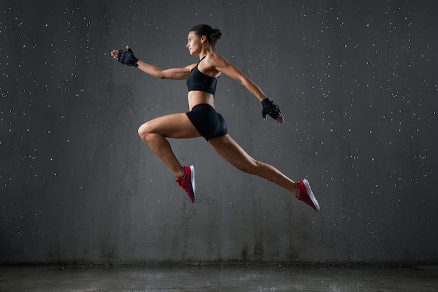 Strong wet woman posing during jump