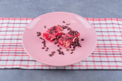 Turkish Delight Rahat Lokum with Pistachios and Dry Raisins on Pink Plate