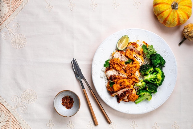 Crispy chicken cutlet with katsu sauce, white rice, and broccoli on a stone table