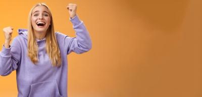 Cheerful Young Woman Supporting and Cheering on Her Sister’s Team with Hope and Dedication