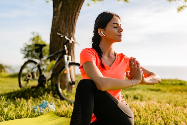 Slim beautiful woman doing yoga in the morning at the park