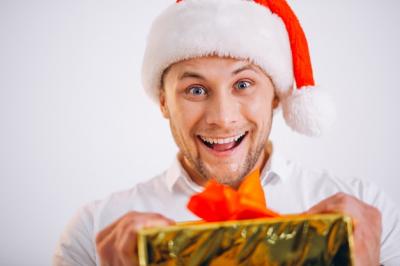 Portrait of a Man in Santa Hat Holding Christmas Golden Present Box