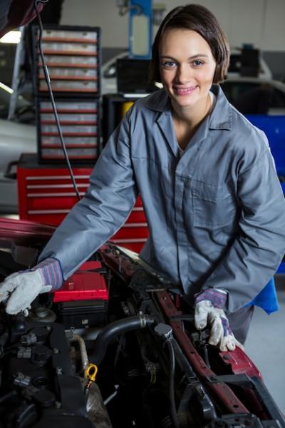 Female mechanic servicing car