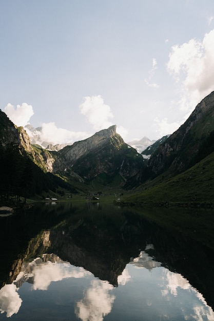 Landscape Shot of Mountains and Hills Reflecting in a Lake Under a Clear Sky