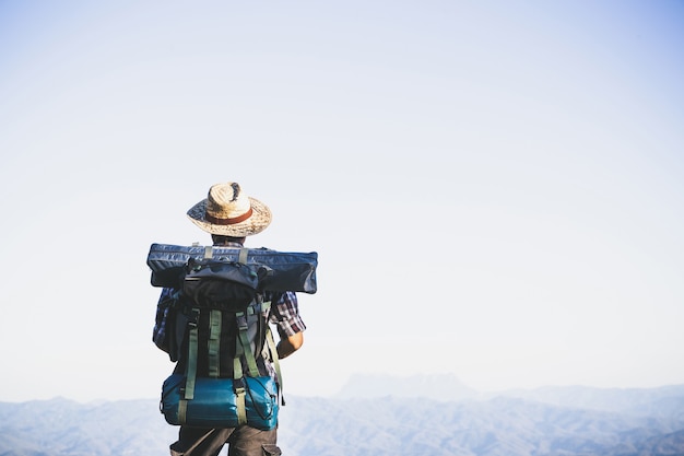 Tourist from Mountain Top: Man with Big Backpack Against Sunlight