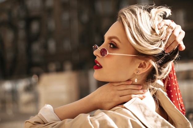 Beautiful Blonde Woman in Red Sunglasses Touches Hair – Free Stock Photo