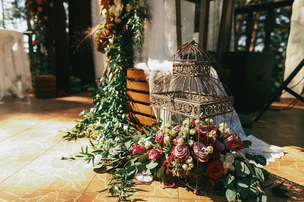 Decorative Bird Cage Filled with Red Roses, Spearworts, and Greenery