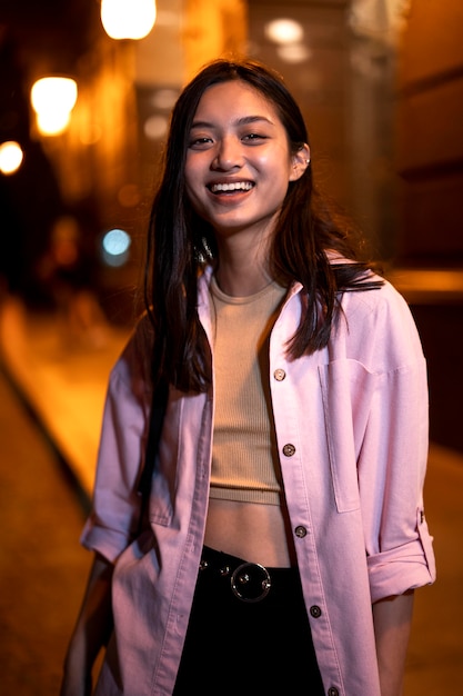 Portrait of beautiful woman at night in the city lights