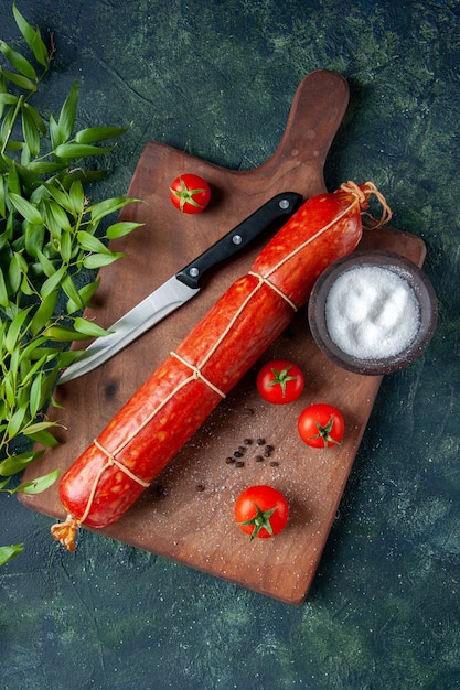 Top view fresh tasty sausage with tomatoes on a dark background