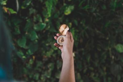 Close-up of woman’s hand holding golden retro compass