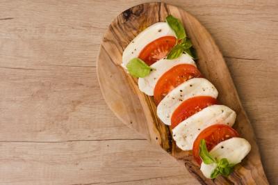 Overhead view of Italian Caprese Salad with Mozzarella Cheese, Basil, and Tomatoes on Serving Board