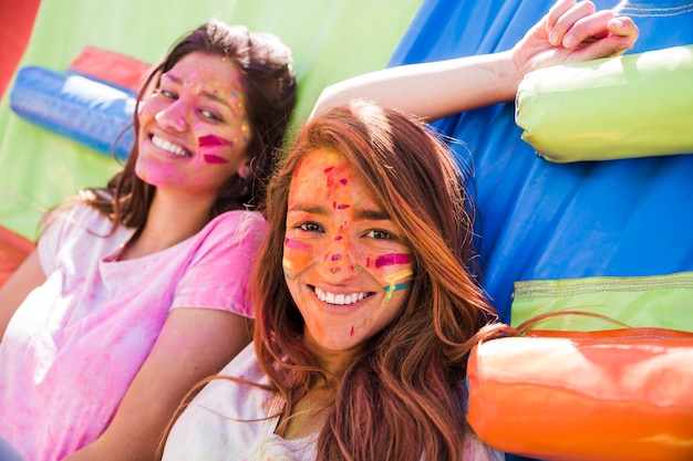 Portrait of Two Young Women Smiling with Holi Color Face