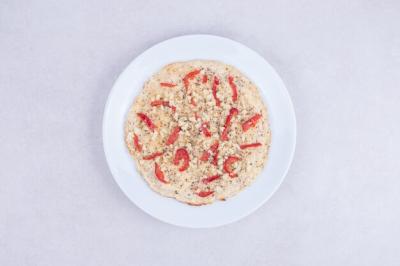 Pizza with peppers on wooden plate on white Free Stock Photo