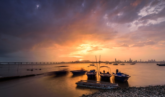 Motorboats parked on the water with sunset and a city visible