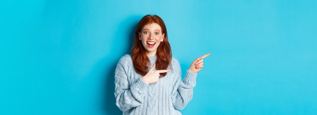 Teenage Girl with Red Hair and Freckles Pointing at Logo