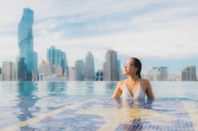 Portrait of a Beautiful Young Asian Woman Relaxing and Smiling by an Outdoor Swimming Pool