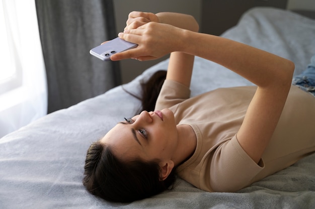 High Angle Girl in Bed with Smartphone – Free Download